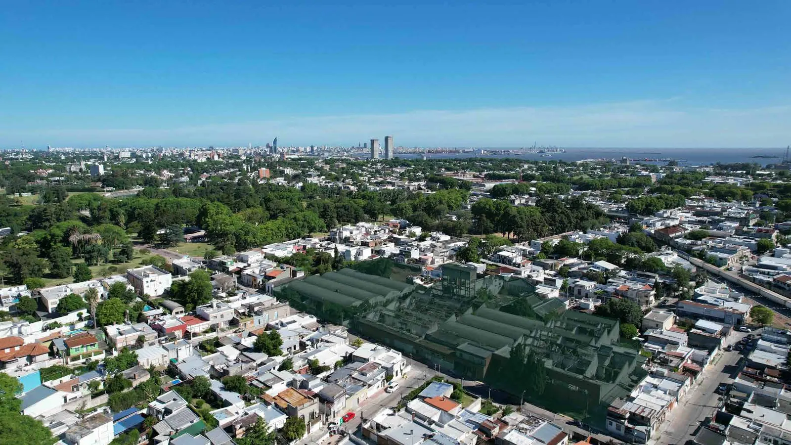 El predio visto desde el aire, con el Parque Prado y el skyline de Montevideo al fondo